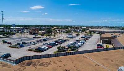 Elevated view over a shopping center parking lot and flat land in the Katy, Texas area