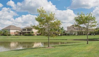 Homes overlooking a pond and open lawn in a Pearland, Texas neighborhood